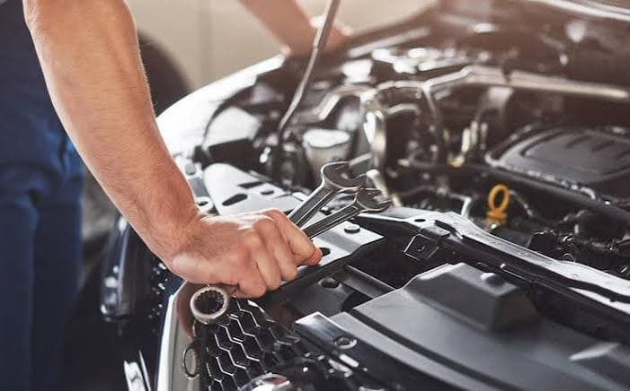 Mechanic working on a vehicle in a service bay